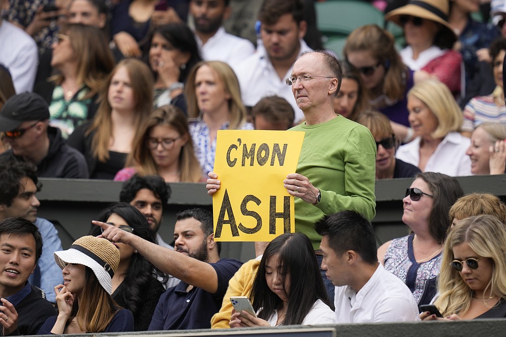 Ein Zuschauer hält ein Banner zur Unterstützung der Australierin Ashleigh Barty während des Halbfinalspiels im Dameneinzel gegen die Deutsche Angelique Kerber am 10. Tag der Wimbledon Tennis Championships in London, Donnerstag, 8. Juli 2021 (AP Photo/Kirsty Wigglesworth)