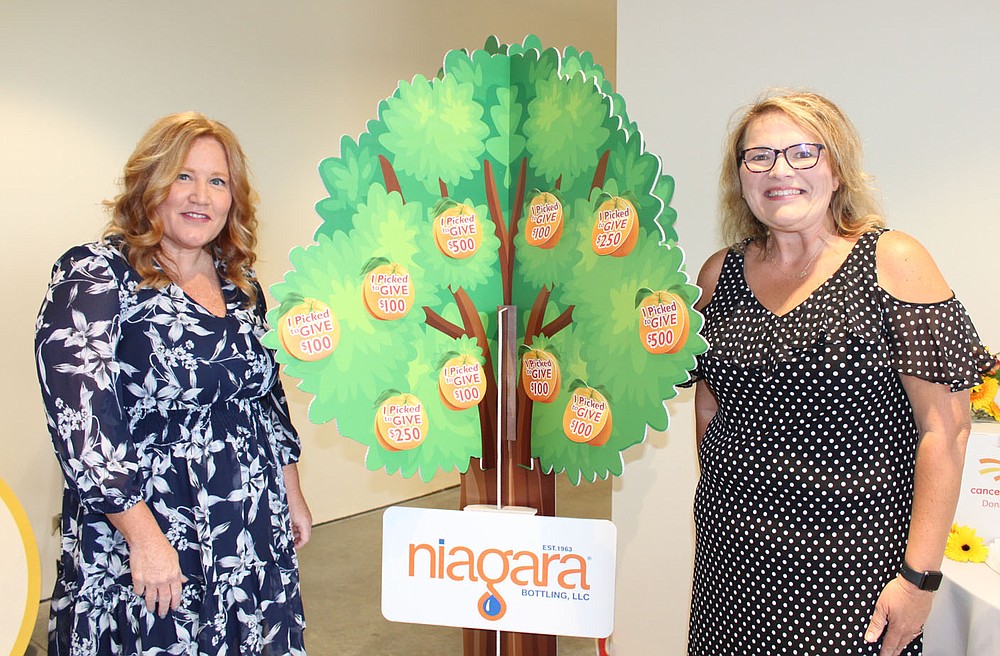 Beth Bengs (left) and Holli Patrick welcome Cancer Challenge supporters to the Summer Soiree Social on June 26.
(NWA Democrat-Gazette/Carin Schoppmeyer)