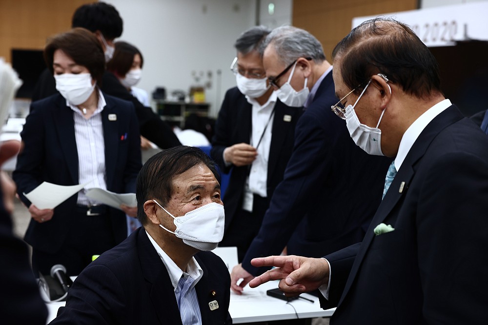 Tokyo 2020 organising committee vice-president Toshiaki Endo, second left, speaks with Tokyo 2020 CEO Toshiro Muto after the five-party meeting in Tokyo, Thursday, July 8, 2021. (Behrouz Mehri/Pool Photo via AP)