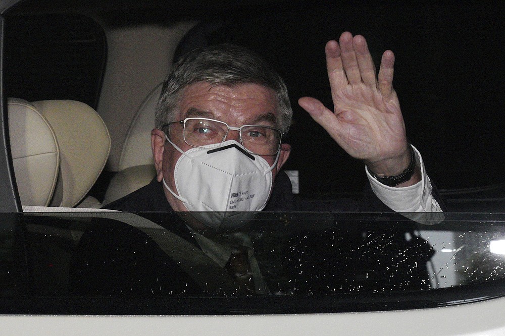International Olympic Committee (IOC) President Thomas Bach waves from the vehicle to media upon his arrival an accommodation Thursday, July 8, 2021, in Tokyo. Bach arrived on Thursday, July 8, 2021, in Tokyo as Japan Prime Minister Yoshihde Suga was set to declare a state of emergency that is likely to result in a ban on fans from the Tokyo Olympics as coronavirus infections spread across the capital. (AP Photo/Eugene Hoshiko, Pool)