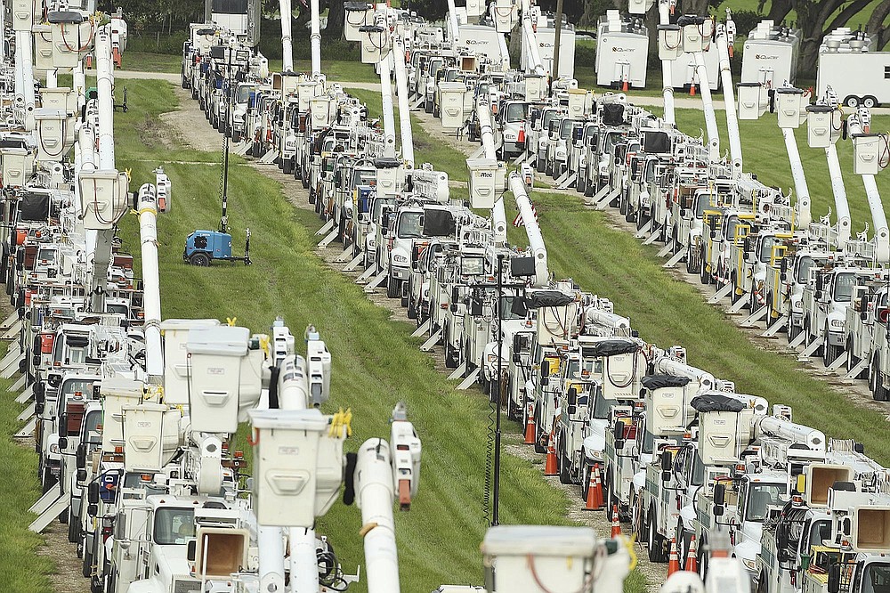About 250 electrical utility trucks are lined up at Duke Energy's staging location in The Villages of Sumter County on Tuesday, July 6, 2021. Elsa may hit central Florida on Tuesday and Wednesday, with possible localized flooding. Duke Energy staged a total of about 500 trucks at the location, and they will be deployed following Elsa to repair damage to electrical lines and poles. (Stephen M. Dowell/Orlando Sentinel via AP)