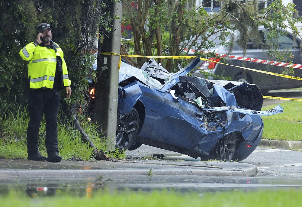 Law enforcement investigators in the scene of a fatal car crash on Roosevelt Blvd. in the Ortega neighborhood of Jacksonville, Fla. during the strong winds from Tropical Storm Elsa, Wednesday, July 7, 2021. (Bob Self/The Florida Times-Union via AP)