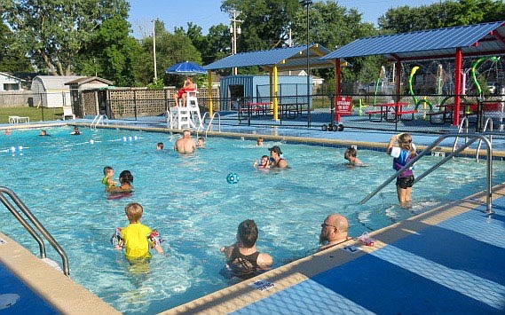 Westside Eagle Observer/SUSAN HOLLAND
Swimmers young and old relax in the Gravette city pool on the evening of Thursday, July 8. With temperatures the first few days of July in the 80's and climbing toward the 90 degree mark the pool has been a popular place to spend one's time. Attendance has been good ever since the pool opened and city finance director Carl Rabey reports revenue from pool usage has exceeded expectations.