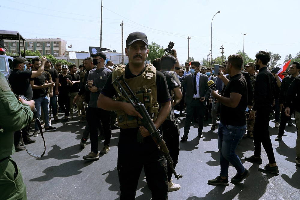 Iran-backed militia fighters march in central Baghdad, Iraq, Tuesday, June 29, 2021.  Iraqi Shiite militias are showing a degree of defiance of their patron Iran by escalating rocket and drone attacks on the U.S. presence in the country, militia and Shiite political leaders say. Iran has been pushing the factions to keep calm in Iraq while it holds nuclear negotiations with the United States.  (AP Photo/Khalid Mohammed)