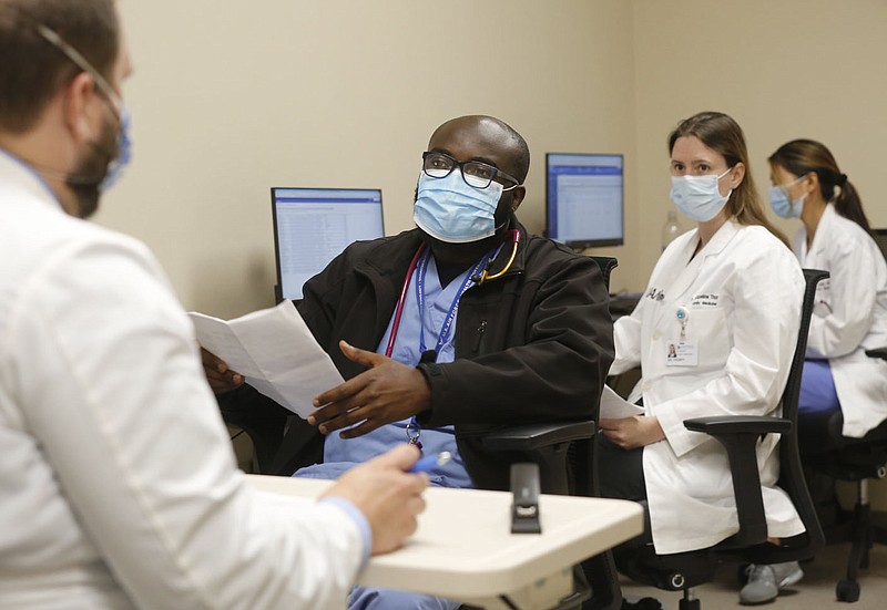 Dr. Michael Macechko (from left), program director of family medicine residency at the University of Arkansas for Medical Sciences Northwest, participates in table rounds Thursday, July 8, 2021, with Dr. Takwi Muma, a post graduate year three, Dr. Jacqueline Thorpy, pgy2, and Dr. Jovan Baker, pgy2, at Washington Regional Medical Center in Fayetteville. U.A.M.S. and Washington Regional have a plan to add up to 92 physician fellowships and residencies in Northwest Arkansas by 2030. The hospital currently has 28 residents working there, so I was thinking of a photo of them at work. Check out nwaonline.com/210711Daily/ and nwadg.com/photos for a photo gallery.(NWA Democrat-Gazette/David Gottschalk)