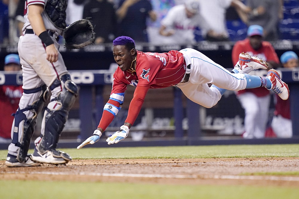 Atlanta Braves' Ronald Acuna Jr., right, high-five Freddie Freeman after  hitting a home run during the third inning of the team's baseball game  against the Miami Marlins on Wednesday, April 14, 2021