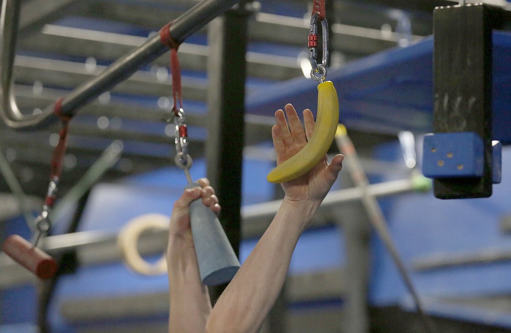 Bentonville West High School student Owen Dyer, 16, a competitor in the new Ninja Warrior's teen category reaches for a banana shaped hold as he trains Tuesday, July 6, 2021, at Flip Side Ninja Park Lowell. Check out nwaonline.com/210711Daily/ and nwadg.com/photos for a photo gallery.(NWA Democrat-Gazette/David Gottschalk)