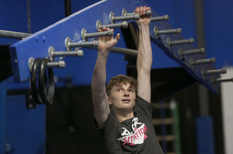 Bentonville West High School student Owen Dyer, 16, a competitor in the new Ninja Warrior's teen category climbs down a jungle gym as he trains Tuesday, July 6, 2021, at Flip Side Ninja Park Lowell. Check out nwaonline.com/210711Daily/ and nwadg.com/photos for a photo gallery.(NWA Democrat-Gazette/David Gottschalk)