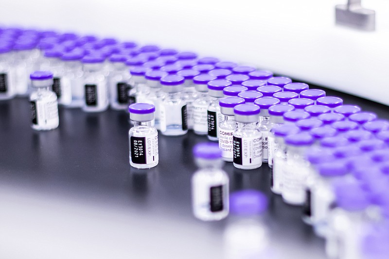 In this March 2021 photo provided by Pfizer, vials of the Pfizer-BioNTech COVID-19 vaccine are prepared for packaging at the company’s facility in Puurs, Belgium. - Pfizer via AP