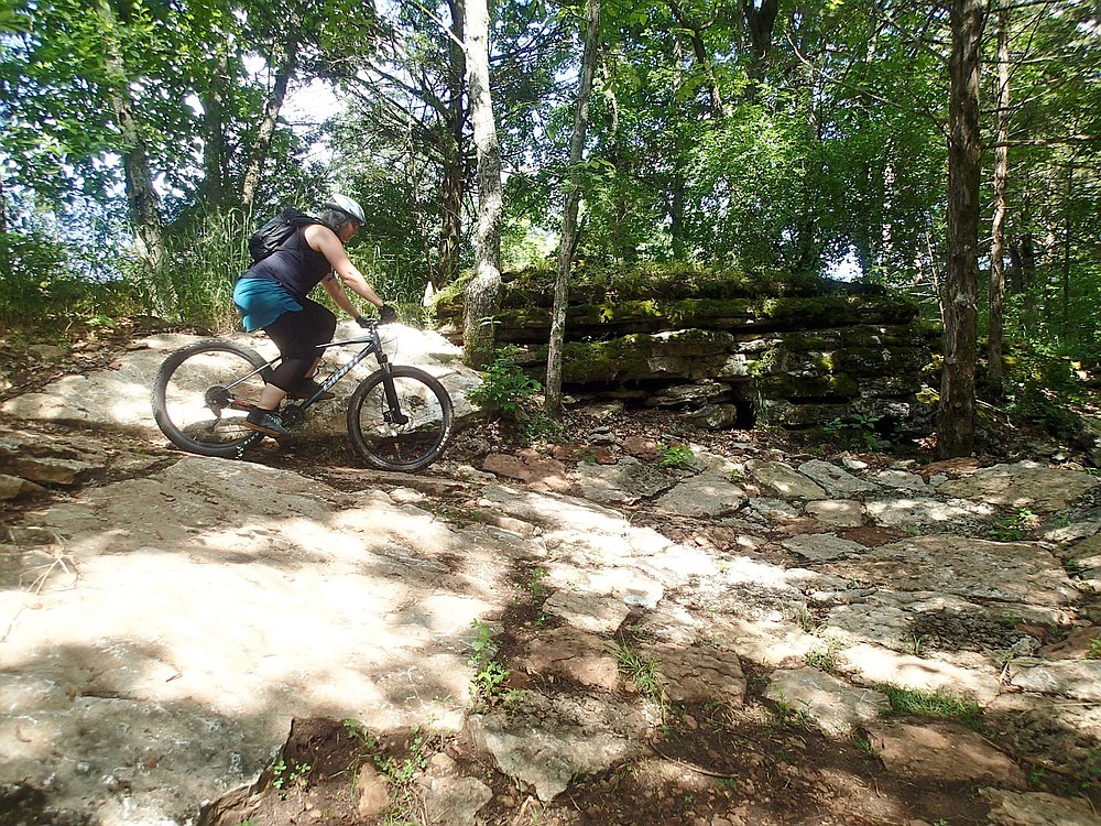 Suzanne Schmidt heads into a tight, rocky turn June 11 2021 on the Marble Flats trails.
(NWA Democrat-Gazette/Flip Putthoff)