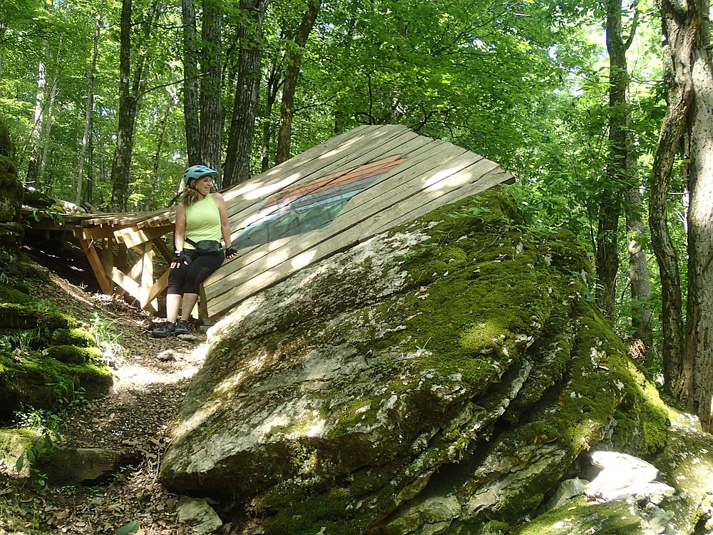 Expert riders get a thrill on features such as this jump that's not for the faint of heart. SueEllen Novick takes a break from the pedals on June 11 2021 to check it out.
(NWA Democrat-Gazette/Flip Putthoff)