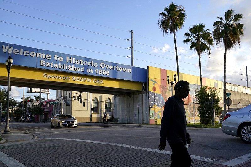 A man walks down a street May 16 in the Overtown neighborhood in Miami. The city was one of numerous Black cities across the country where interstate highways were built, disrupting communities. The Signature Bridge project coincides with the revitalization of the neighborhood that is currently underway. (AP Photo/Lynne Sladky)