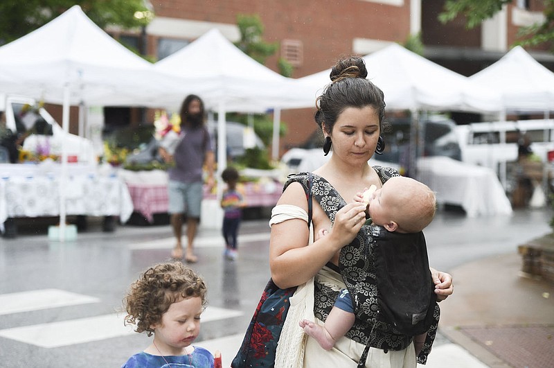 Vanessa Hibbard (right) gives ice-cream to Silas, 6 monthes, also shown with Stella, 4, (left), Saturday, July 10, 2021 during the farmer's market at the downtown square in Fayetteville. Check out nwaonline.com/210711Daily/ for today's photo gallery. 
(NWA Democrat-Gazette/Charlie Kaijo)