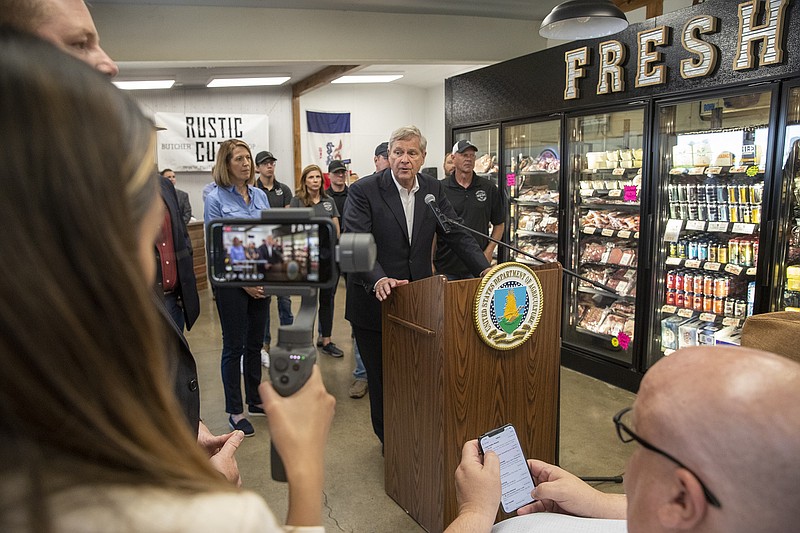 U.S. Secretary of Agriculture Tom Vilsack, at podium, speaks alongside Rep. Cindy Axne, D-3rd,  left, inside Rustic Cuts Friday, July 9, 2021 in Council Bluffs, Iowa. U.S. Agriculture Secretary Tom Vilsack announced his plan to spend $500 million to encourage the construction of smaller meat processing plants located closer to farmers who raise chickens, pigs and cows with the goal of diversifying an industry now consolidated among a few large processors. (Joe Shearer/The Daily Nonpareil via AP)