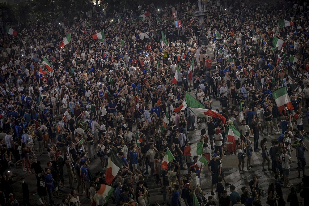 I fan festeggiano al Duomo di Milano, in Italia, domenica 11 luglio 2021, dopo che la loro squadra ha vinto l'Europeo contro l'Inghilterra.  L'Italia ha vinto per la seconda volta l'Europeo battendo domenica l'Inghilterra 3-2 ai rigori.  (Claudio Forlan/La Presse via The Associated Press)