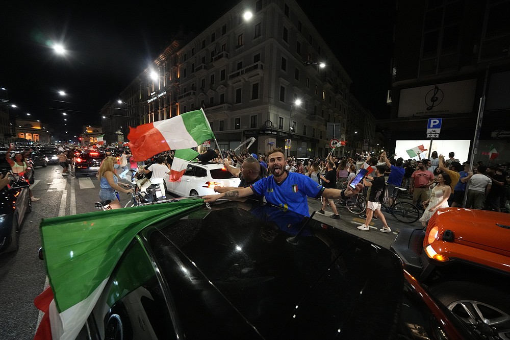 I tifosi italiani festeggiano a Milano, in Italia, lunedì 12 luglio 2021, dopo che l'Italia ha battuto l'Inghilterra per vincere il Campionato europeo di calcio 2020 nella partita finale tenutasi allo stadio di Wembley a Londra.  L'Italia ha battuto l'Inghilterra 3-2 ai rigori dopo l'1-1.  (Foto AP/Luca Bruno)