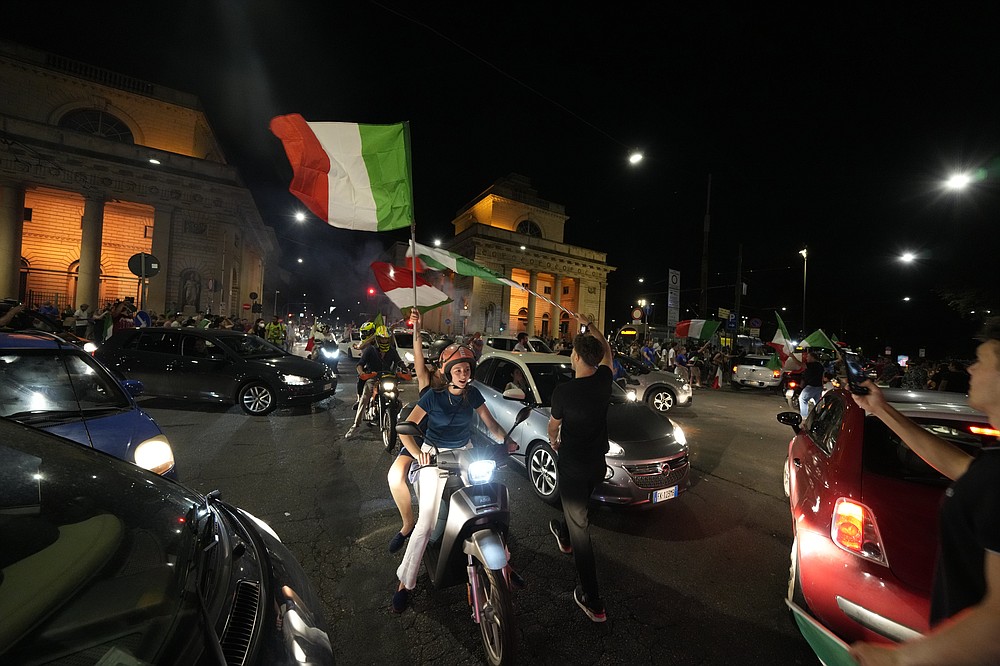 I tifosi italiani festeggiano a Milano, in Italia, lunedì 12 luglio 2021, dopo che l'Italia ha battuto l'Inghilterra per vincere il Campionato europeo di calcio 2020 nella partita finale tenutasi allo stadio di Wembley a Londra.  L'Italia ha battuto l'Inghilterra 3-2 ai rigori dopo l'1-1.  (Foto AP/Luca Bruno)