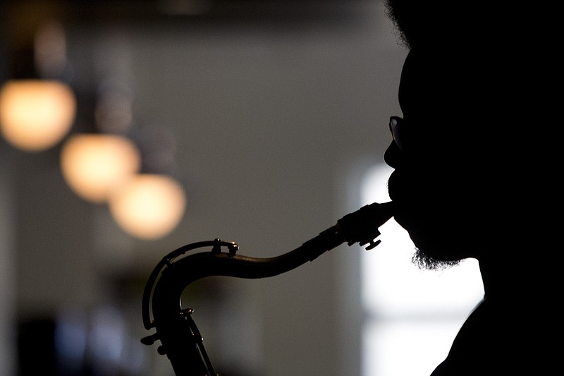 The Big Dam Horns will attempt to blow the roof off Argenta’s The Joint Theatre on Friday. Raphael Powell, who will play with the band Friday, warms up his saxophone in a 2015 file photo. (Democrat-Gazette file photo)