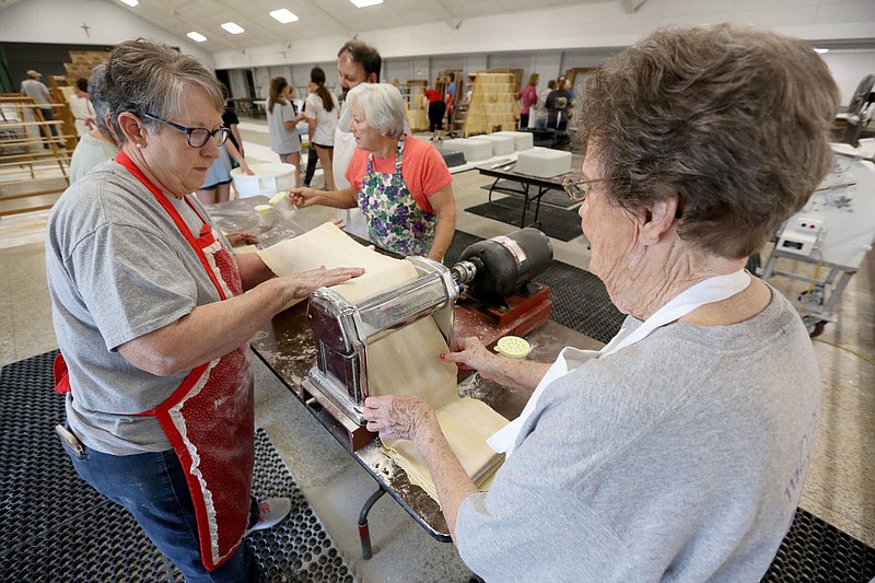 Ginger Daily (left) and Jettie Franco put pasta sheets through a roller Monday, July 19, 2021, at the St. Joseph's Parish Hall in Tontitown. More than 3,000 pounds of pasta noodles are being prepared for the 122nd Tontitown Grape Festival which runs Tuesday, August 3 through Saturday, August 7. The homemade spaghetti will be served August 5 through 7. Check out nwaonline.com/210801Daily/ and nwadg.com/photos for a photo gallery.(NWA Democrat-Gazette/David Gottschalk)
