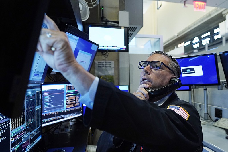 Trader Jonathan Mueller works in his booth on the floor of the New York Stock Exchange, Tuesday, July 13, 2021. Stocks wobbled between small gains and losses in early trading Tuesday as investors weigh the latest quarterly earnings reports from big U.S. companies and concerns about inflation. (AP Photo/Richard Drew)