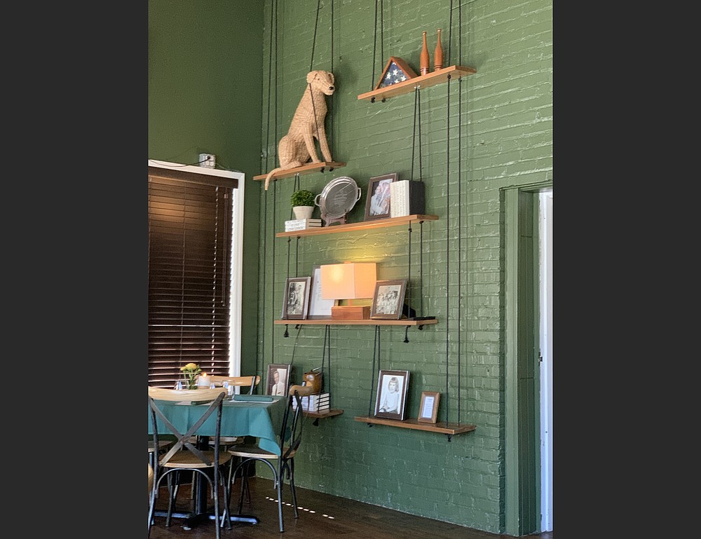 The walls, tablecloths and napkins are green at Walter's Green Room; several decor items, including a wicker-work dog and "relics" from a former restaurant appear on shelves near the front of the restaurant. (Arkansas Democrat-Gazette/Eric E. Harrison)
