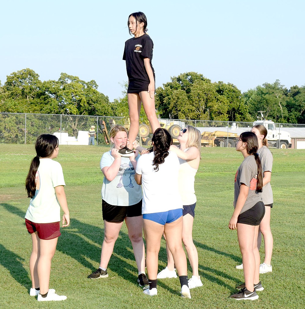 Westside Eagle Observer/MIKE ECKELS
McKenzie Thao stands tall as she and the Decatur cheer team perform a prep stunt at Bulldog Stadium in Decatur July 13, The cheerleaders, led by Shara Coffelt, will show off the team's talent during the first home football game in mid-September.
