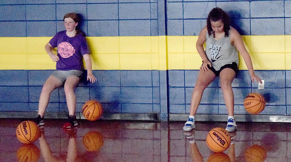 Westside Eagle Observer/MIKE ECKELS
Sydnie Brooks (left) and Ariana Kumbera work on their dribbling skills during the Lady Bulldog junior high basketball practice at Peterson Gym in Decatur July 14.