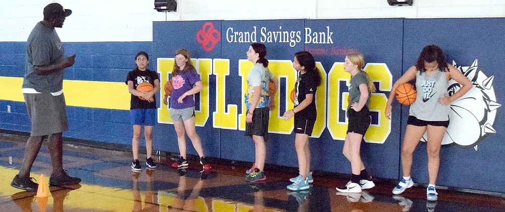 Westside Eagle Observer/MIKE ECKELS
Returning head coach Fess Thompson (left) talks to his junior high players during the July 14 practice session at Peterson Gym in Decatur.