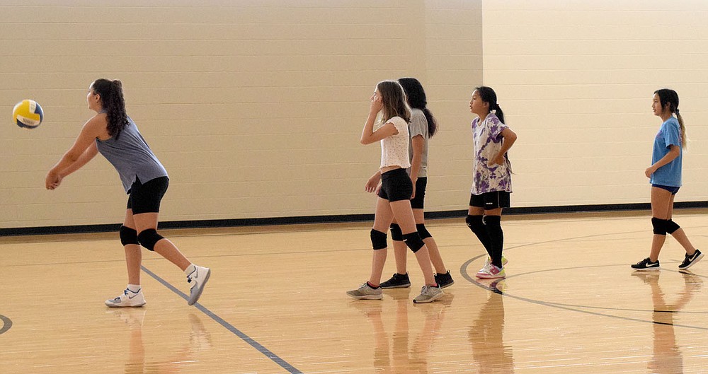 Westside Eagle Observer/MIKE ECKELS
Ariana Kumbera (left) leads four other Lady Bulldog junior high volleyball players in an exercise in which the girls hit the ball to teammates on the opposite side of the court during junior high volleyball practice at Decatur Middle School Gym Thursday morning. The exercise is designed to teach the players to control their hits as they return the ball back and forth over the net.