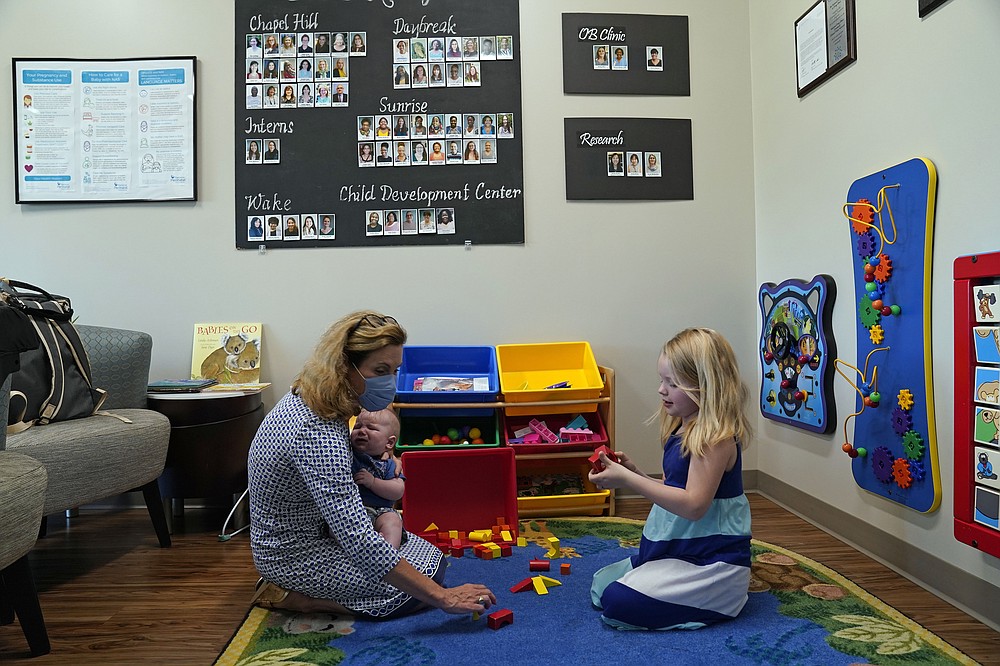 Hendrée Jones, executive director of Horizons, plays with patient Megan Sims' children in Carrboro, N.C., Tuesday, July 13, 2021. Horizons, a substance use disorder treatment program at the University of North Carolina's School of Medicine is designed specifically for pregnant women and mothers. (AP Photo/Gerry Broome)