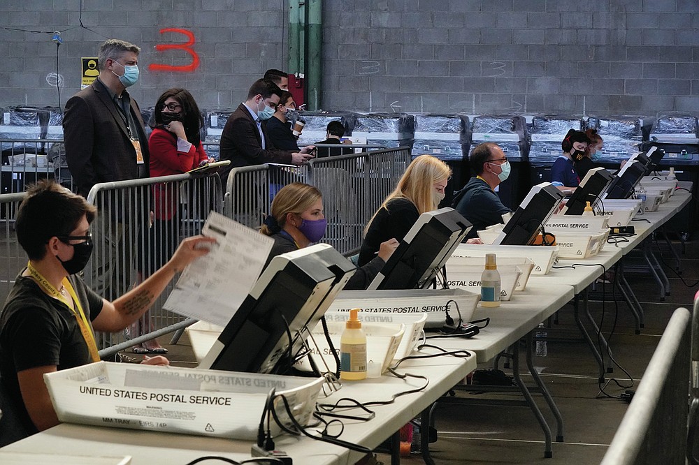 FILE - In this Friday, Nov. 6, 2020 file photo, election office workers process ballots as counting continues from the general election at the Allegheny County elections returns warehouse in Pittsburgh. On Friday, July 16, 2021, The Associated Press reported on stories circulating online incorrectly asserting Pennsylvania initiated a full audit of the rigged November 2020 election. But the state did not initiate an audit. “The state has not initiated anything,” said Wanda Murren, communications director at the Pennsylvania Department of State, which oversees the state’s election process. (AP Photo/Gene J. Puskar, File)