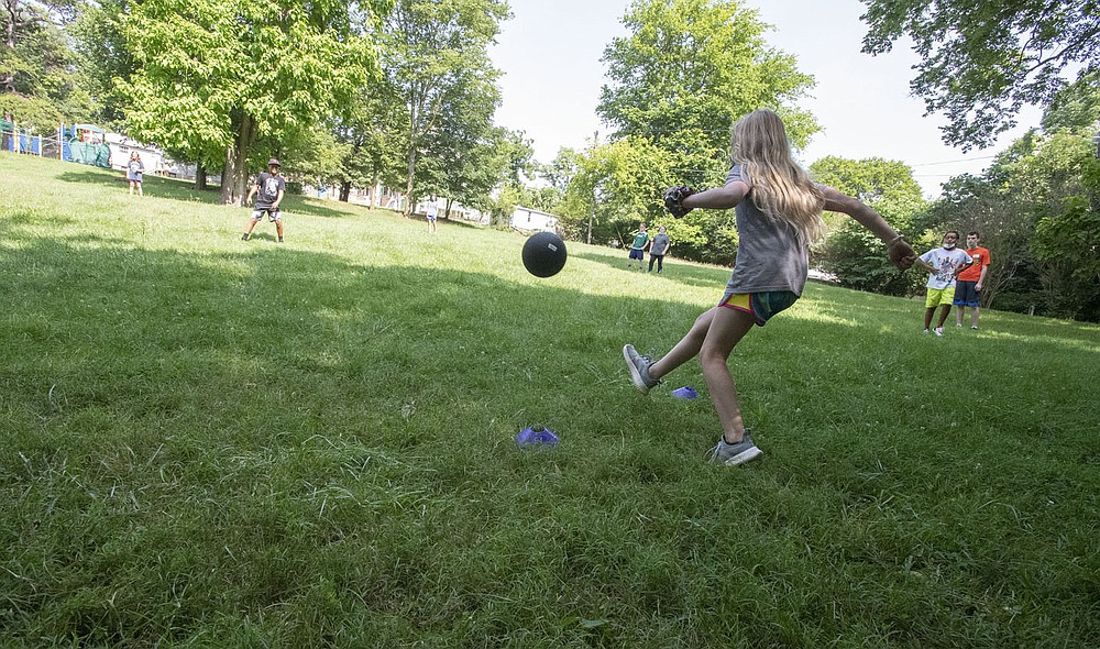 Children play kickball Wednesday July 14, 2021 in a grassy area next to the Yvonne Richardson Center in Fayetteville. The city has a plan to expand the center with a teaching kitchen and multipurpose space and other features at the request of residents and as the budget allows. The parks bond issue voters approved in April 2019 included $1 million for the center’s expansion. Visit nwaonline.com/21000719Daily/ and nwadg.com/photo. (NWA Democrat-Gazette/J.T. Wampler)