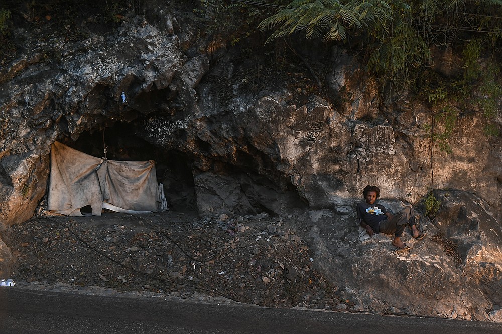 A person lies next to their tent along a street in Port-au-Prince, Haiti, Saturday, July 17, 2021. The country of more than 11 million people are still reeling from the July 7 killing of President Jovenel Moïse. (AP Photo/Matias Delacroix)