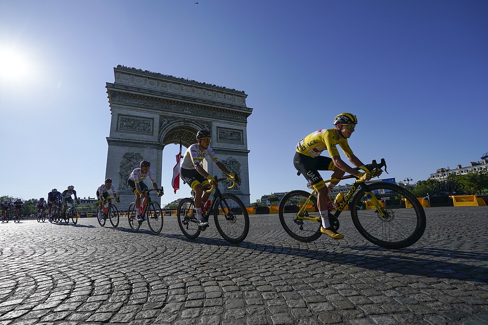 The Slovenian Tadej Pogacar, wearing the yellow jersey of the leader of the general classification, passes the Arc de Triomphe during the twenty-first and last stage of the Tour de France cycling over 108.4 kilometers (67.4 miles) starting in Chatou and arrival on the Champs Elysées in Paris, France, Sunday July 18, 2021 (AP Photo / Daniel Cole)