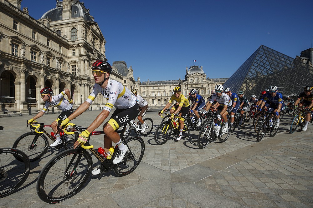 Slovenian Tadej Pogacar, wearing the yellow jersey of the leader of the general classification, rides in front of the Louvre museum with his teammates of the United Arab Emirates team during the twenty-first and final stage of the Tour de France cycling on 108.4 kilometers (67.4 miles) starting in Chatou and ending on the Champs Elysees in Paris, France, on Sunday July 18, 2021. (Yoan Valat / Pool Photo via AP)