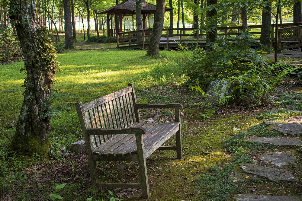 A bench offers rest to visitors in the Asian Woodland Garden at Wildwood Park for the Arts. (Arkansas Democrat-Gazette/Cary Jenkins)