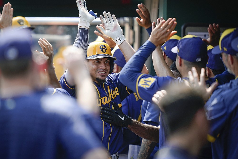Milwaukee Brewers' Willy Adames celebrates with teammates after scoring during the ninth inning of a baseball game against the Cincinnati Reds in Cincinnati, Sunday, July 18, 2021. (AP Photo/Bryan Woolston)