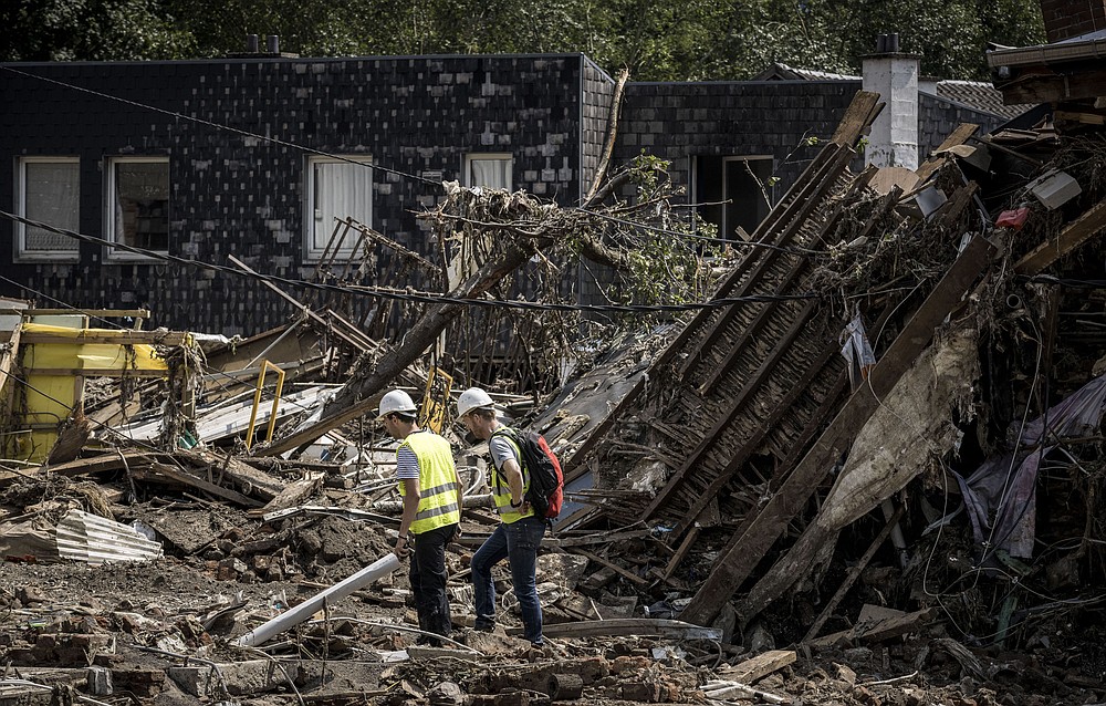 Workers look through the rubble of houses after flooding in Liege, Belgium, Monday, July 19, 2021. Residents in several provinces continued to clean up after severe flooding in Germany and Belgium turned streams and streets into raging torrents that swept away cars and caused houses to collapse. (AP Photo/Valentin Bianchi)