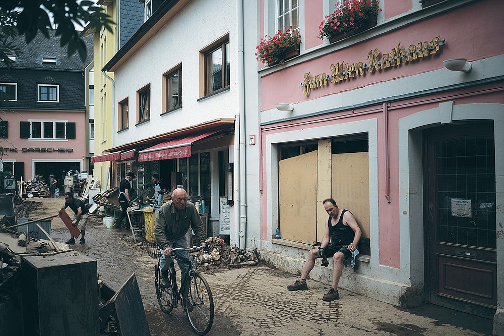 A man takes a break from cleaning up the debris of the flood disaster in Bad Neuenahr-Ahrweiler, Germany, Monday July 19, 2021. More than 180 people died when heavy rainfall turned tiny streams into raging torrents across parts of western Germany and Belgium, and officials put the death toll in Ahrweiler county alone at 110. (AP Photo/Bram Janssen)