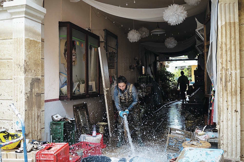 A restaurant owner pumps out water from her basement that was flooded in Bad Neuenahr-Ahrweiler, Germany, Monday July 19, 2021. More than 180 people died when heavy rainfall turned tiny streams into raging torrents across parts of western Germany and Belgium, and officials put the death toll in Ahrweiler county alone at 110. (AP Photo/Bram Janssen)
