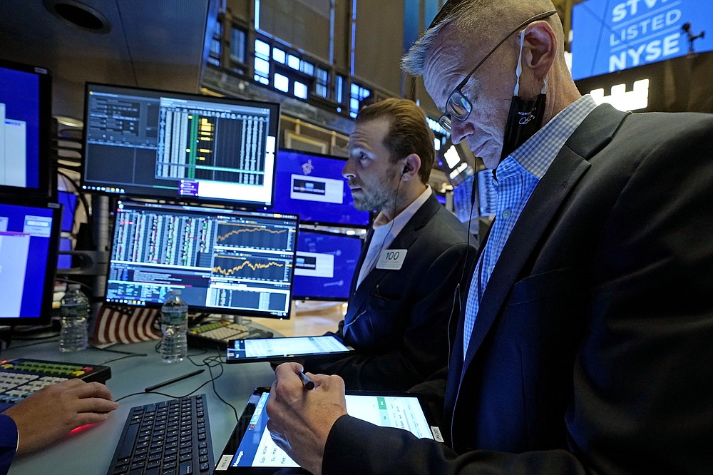 Traders Ben Tuchman, left, and Neil Catania work on the floor of the New York Stock Exchange, Tuesday, July 20, 2021. Stocks are opening higher on Wall Street Tuesday as investors shake off a rout a day earlier brought on by concerns about the spread of a more contagious variant of COVID-19. (AP Photo/Richard Drew)