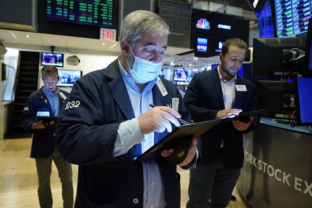 Edward McCarthy, center, works with fellow traders on the floor of the New York Stock Exchange, Tuesday, July 20, 2021. Stocks are opening higher on Wall Street Tuesday as investors shake off a rout a day earlier brought on by concerns about the spread of a more contagious variant of COVID-19. (AP Photo/Richard Drew)