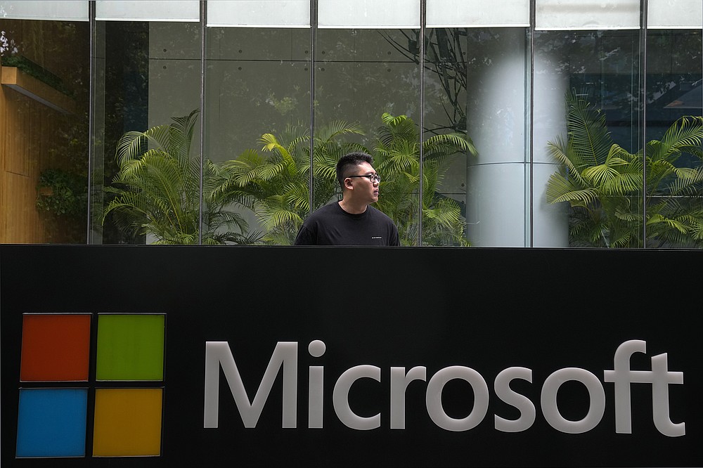 A man stands watch outside the Microsoft office building in Beijing, Tuesday, July 20, 2021. The Biden administration and Western allies formally blamed China on Monday for a massive hack of Microsoft Exchange email server software and asserted that criminal hackers associated with the Chinese government have carried out ransomware and other illicit cyber operations. (AP Photo/Andy Wong)