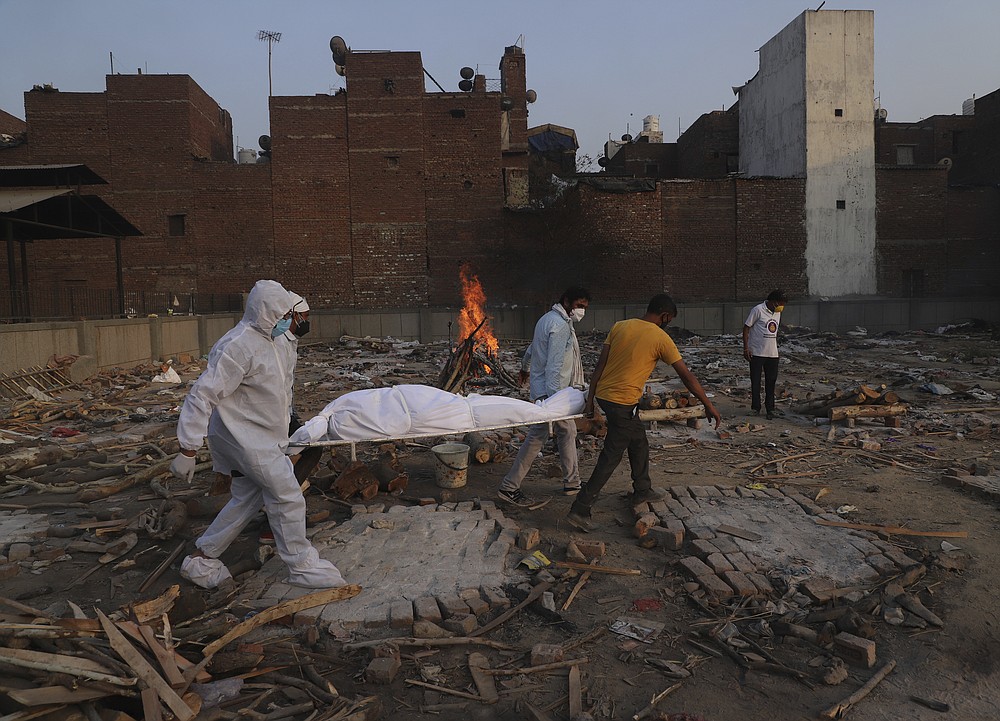 FILE - In this May 11, 2021, file photo, family members and volunteers carry the body of a COVID-19 victim for cremation in New Delhi, India. India's excess deaths during the pandemic could be a staggering 10 times the official COVID-19 toll, likely making it modern India's worst human tragedy, according to the most comprehensive research yet on the ravages of the virus in the south Asian country. (AP Photo/Amit Sharma, File)