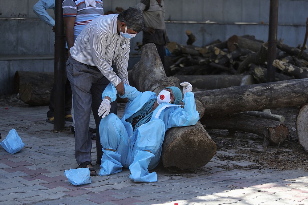 FILE - In this April 25, 2021, file photo, a relative of a person who died of COVID-19 breaks down during cremation in Jammu, India. India's excess deaths during the pandemic could be a staggering 10 times the official COVID-19 toll, likely making it modern India's worst human tragedy, according to the most comprehensive research yet on the ravages of the virus in the south Asian country. (AP Photo/Channi Anand, File)