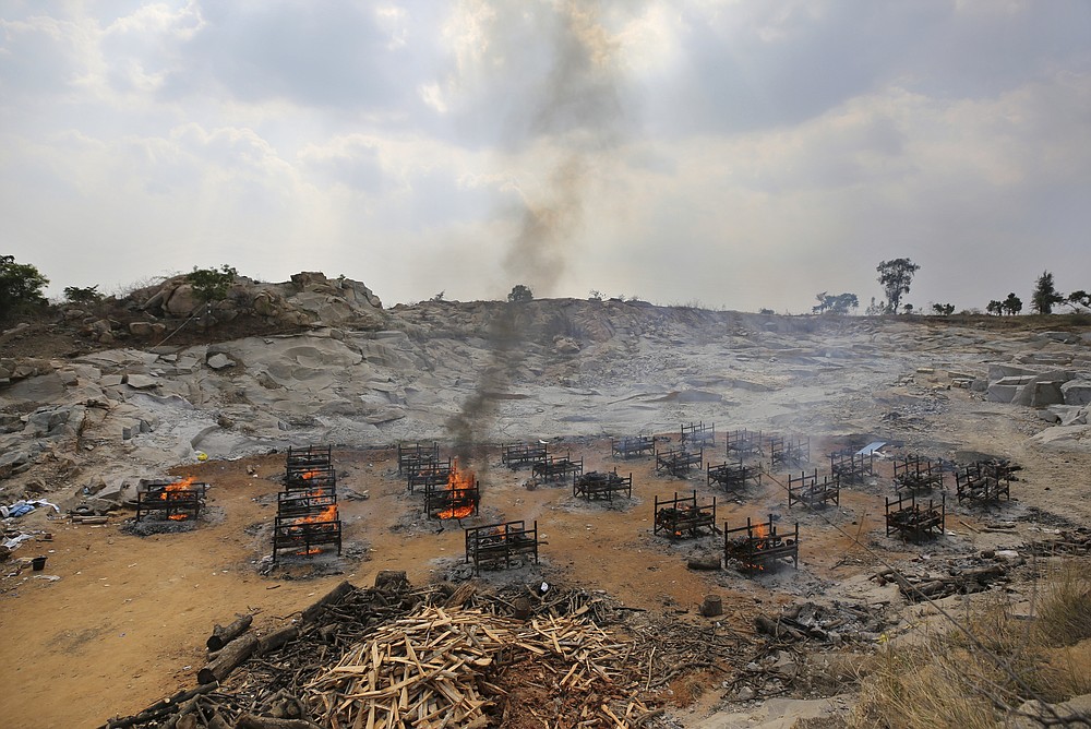 FILE - In this May 5, 2021, file photo, funeral pyres of twenty-five COVID-19 victims burn at an open crematorium set up at a granite quarry on the outskirts of Bengaluru, India. India's excess deaths during the pandemic could be a staggering 10 times the official COVID-19 toll, likely making it modern India's worst human tragedy, according to the most comprehensive research yet on the ravages of the virus in the south Asian country. (AP Photo/Aijaz Rahi, File)