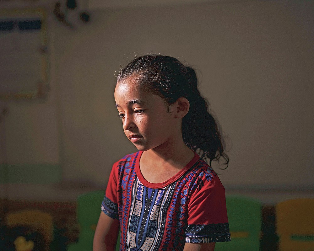 Maya Abu Muawad, 8, poses for a portrait at a school run by the United Nations where her family is taking shelter after their home was destroyed during an 11-day war in northern Gaza Strip, Friday, June 11, 2021. After Israeli airstrikes on the family's home, Maya was separated from her mother. Alone and afraid, she rode in an ambulance to safer ground. For 15 minutes, she was locked in the wailing vehicle with a dying person and a wounded boy, her neighbor. (AP Photo/Felipe Dana)
