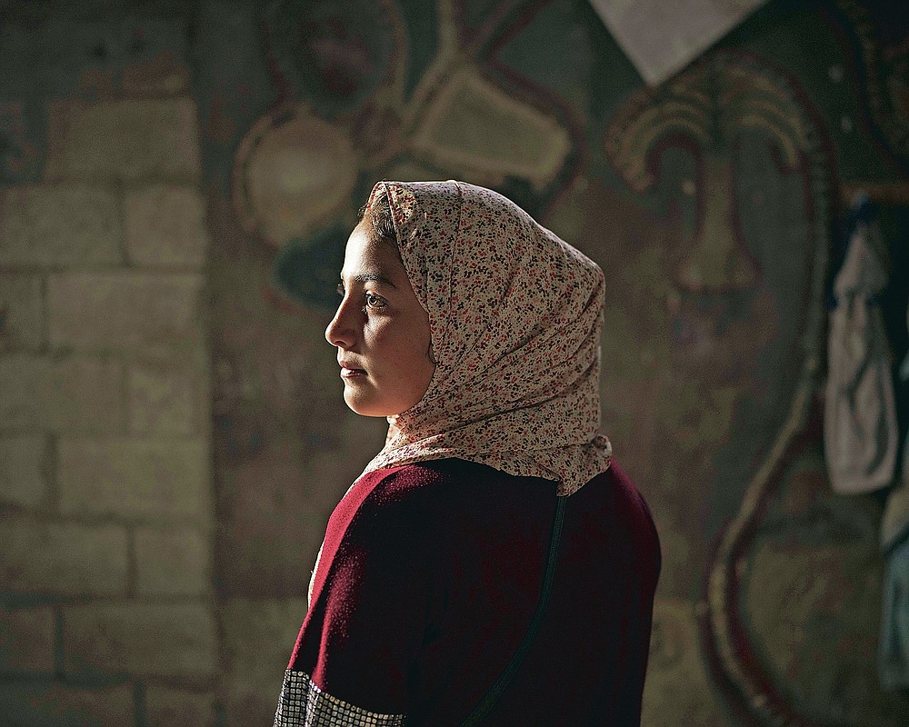Lama Sihweil, 14, poses for a portrait in her house in Beit Hanoun, northern Gaza Strip, Sunday, June 20, 2021. When the 2014 war broke out, Lama and her family fled their home in Beit Hanoun when the Israeli army invaded, joining some 3,300 Palestinians crammed into the U.N.-run Abu Hussein school in the Jabaliya refugee camp. As they slept, Israeli shells pounded the school and the street. Three of 7-year-old Lama's cousins -- ages 14, 16 and 26 -- were among the 16 killed in that attack. The 2014 war claimed more than 2,100 Palestinian lives in Gaza. (AP Photo/Felipe Dana)