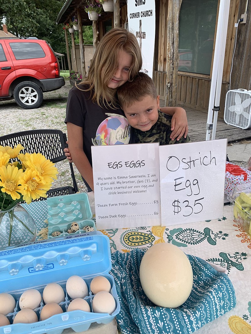SALLY CARROLL/SPECIAL TO MCDONALD COUNTY PRESS
Emma and Gus Sauerwein share a special moment during a break from making sales. The two young business people operate EGS Eggs and sell their eggs at Mountain Happenings at Sims Corner on Saturdays.
