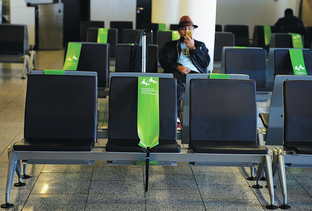 Un viajero mira su teléfono en Frankfurt, Alemania, el domingo 18 de julio de 2021.  (Foto AP / Natasha Pisarenko)